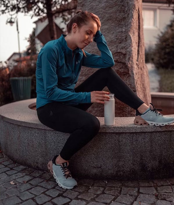 Coach is posing with a big smile wearing sleeveless gray undershirt.